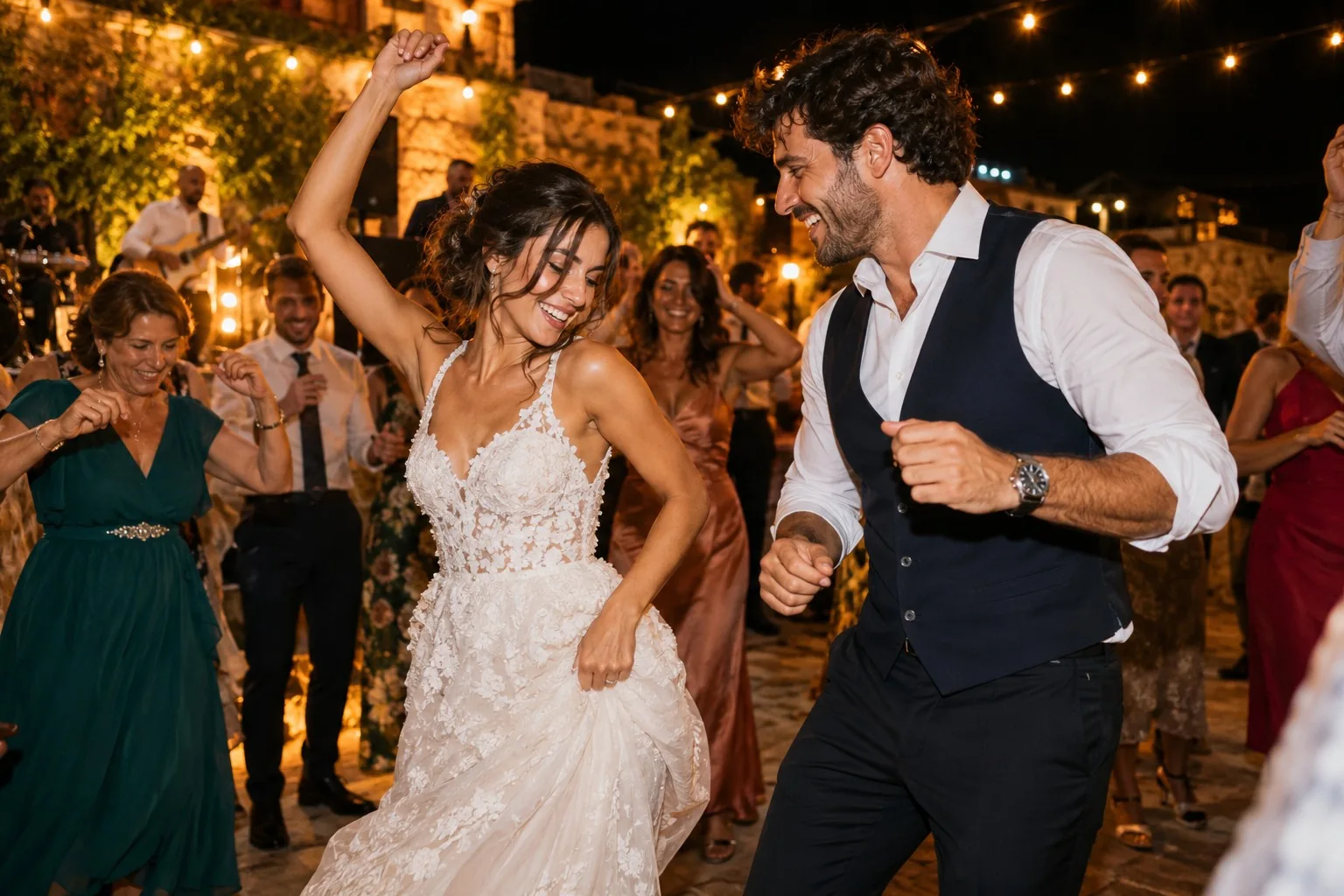 La pareja baila entre sus invitados bajo una guirnalda de luces durante la celebración nocturna.