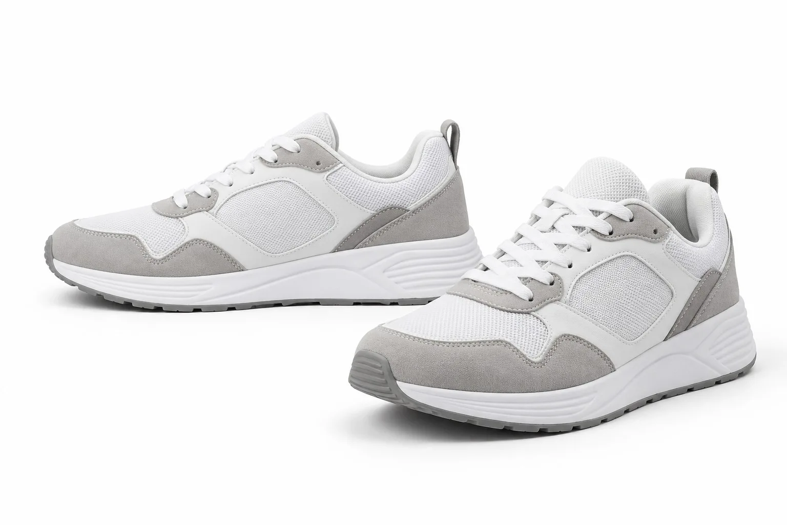 Zapatillas blancas y grises fotografiadas sobre un fondo blanco