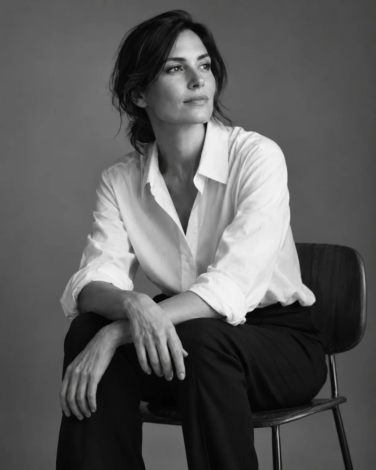 Retrato en blanco y negro de una mujer sentada con camisa blanca